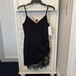 LUSH small black mini w/ asymmetrical lace detail at bottom left